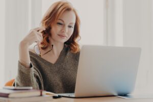 Estudante concentrada em seu laptop, analisando dados e implementando estratégias de SEO para pequenos negócios.