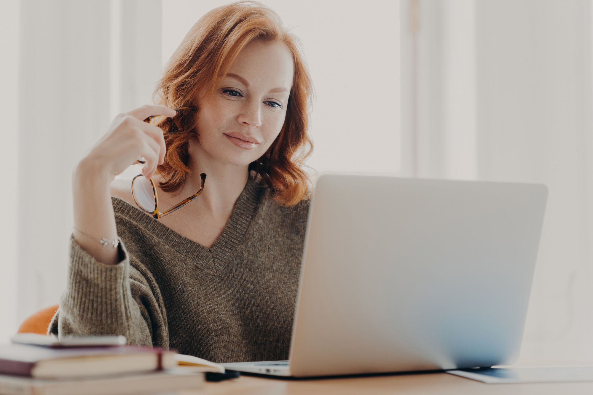 Estudante concentrada em seu laptop, analisando dados e implementando estratégias de SEO para pequenos negócios.